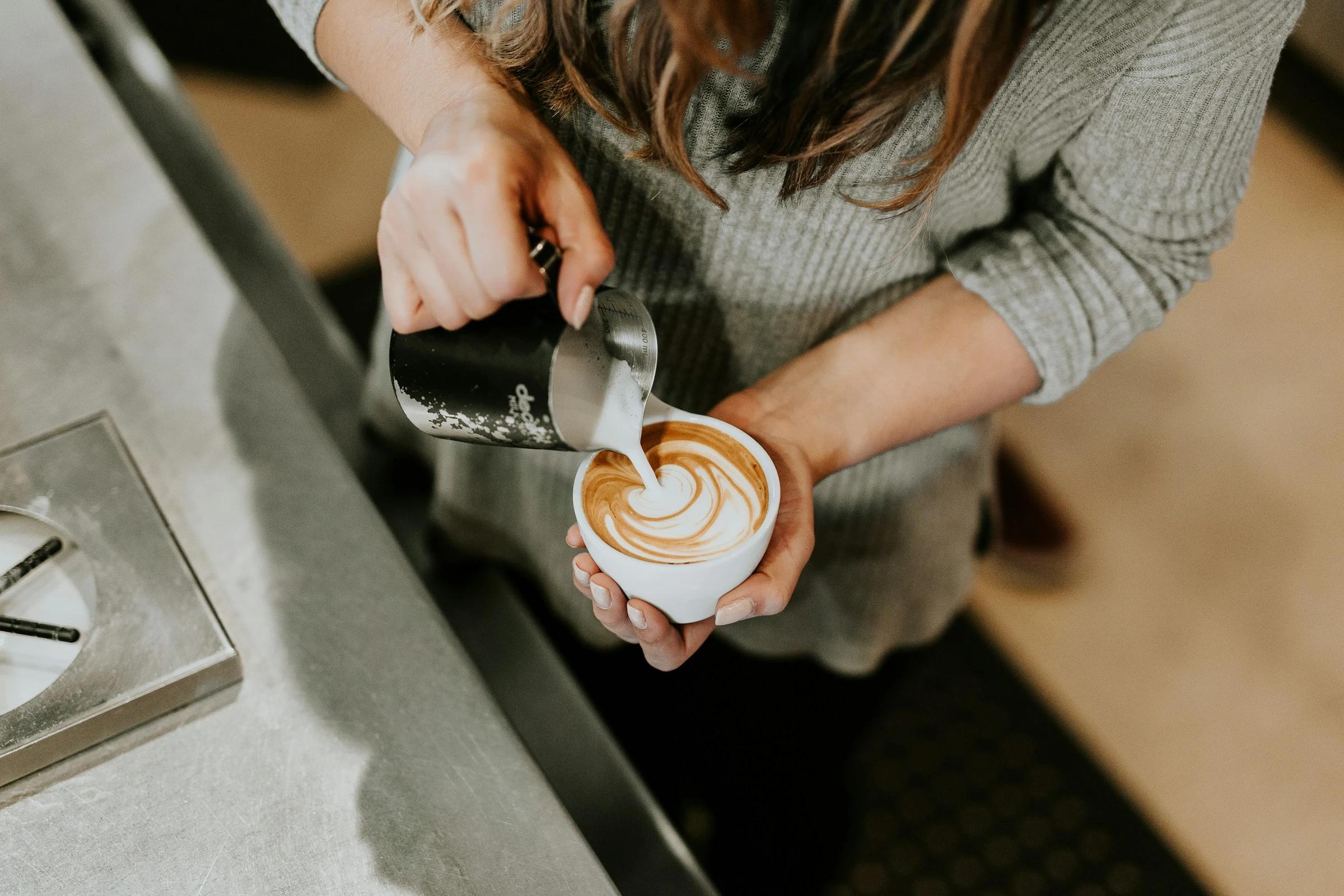 A barista preparing a latte at a machine