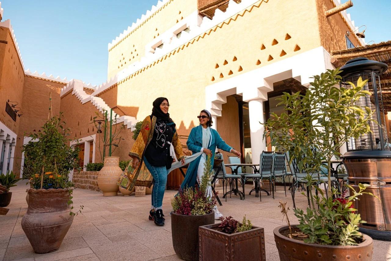 Women walking through Bujairi Terrace in Diriyah together. 