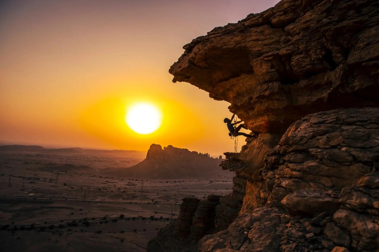 A rock climber scaling a cliff face at the Edge of the World