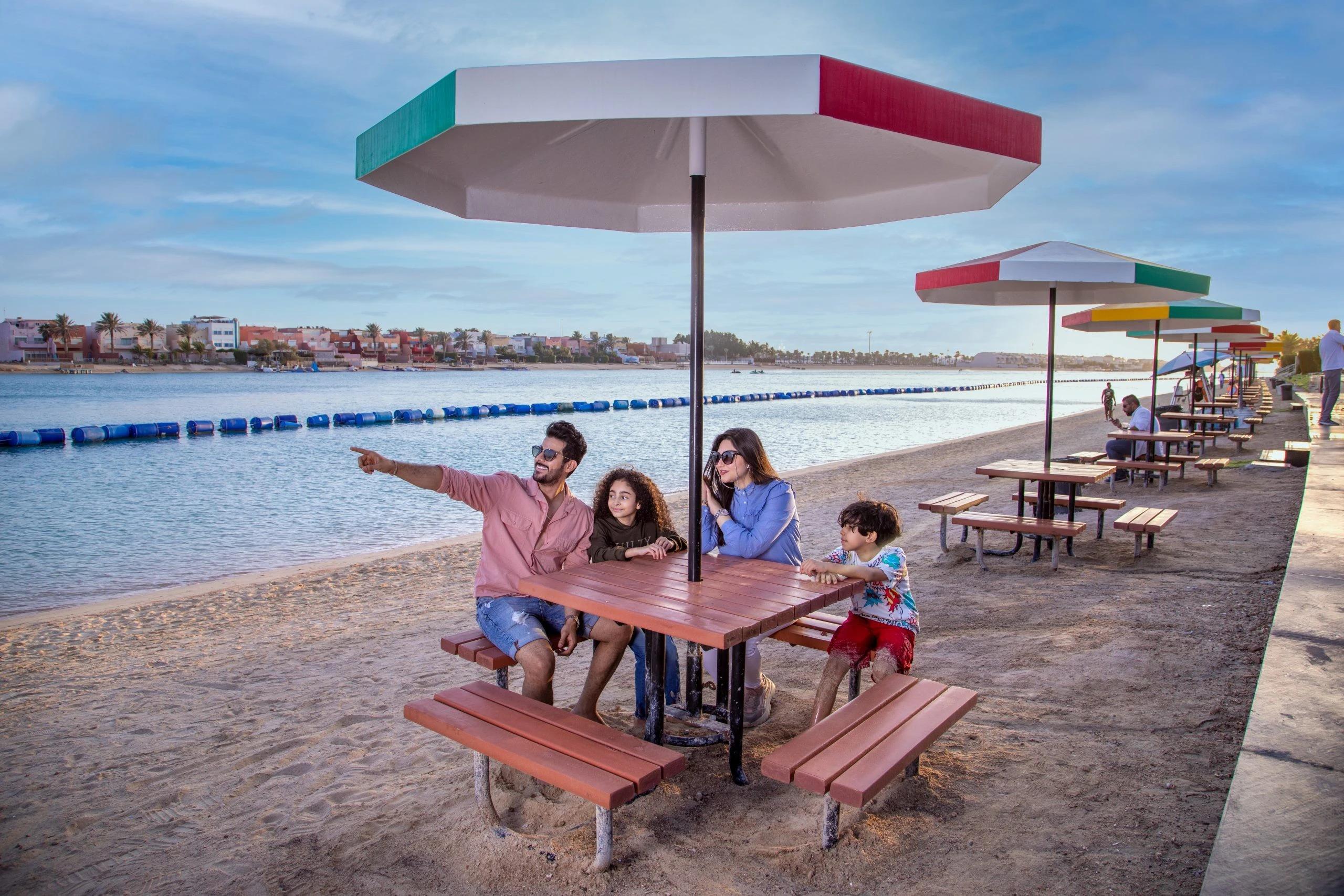 A family sitting around a picnic table next to the sea