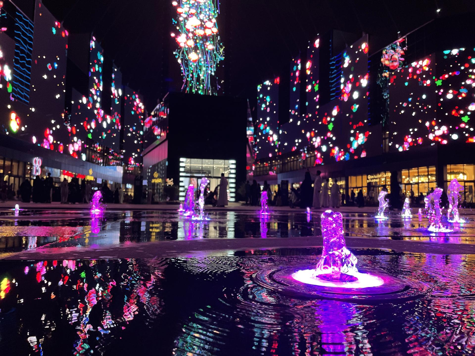 The colours of Boulevard City reflected in water features at night.