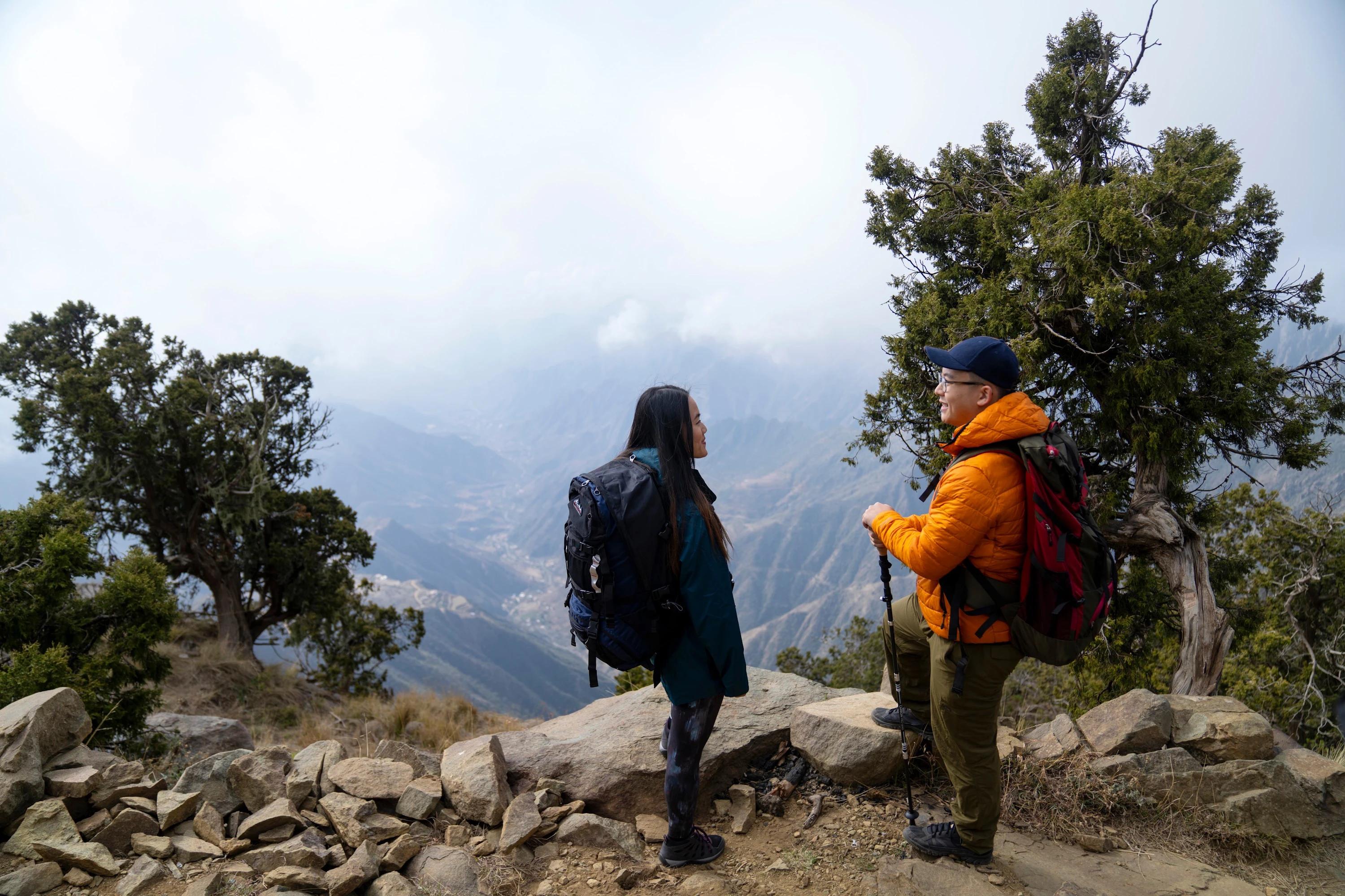 Two tourists admiring mountain views in Aseer